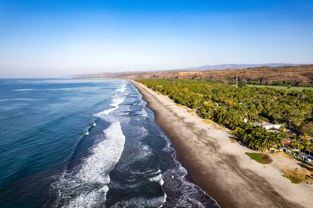 Pacific waves meeting the palm-lined coast of La Libertad, El Salvador